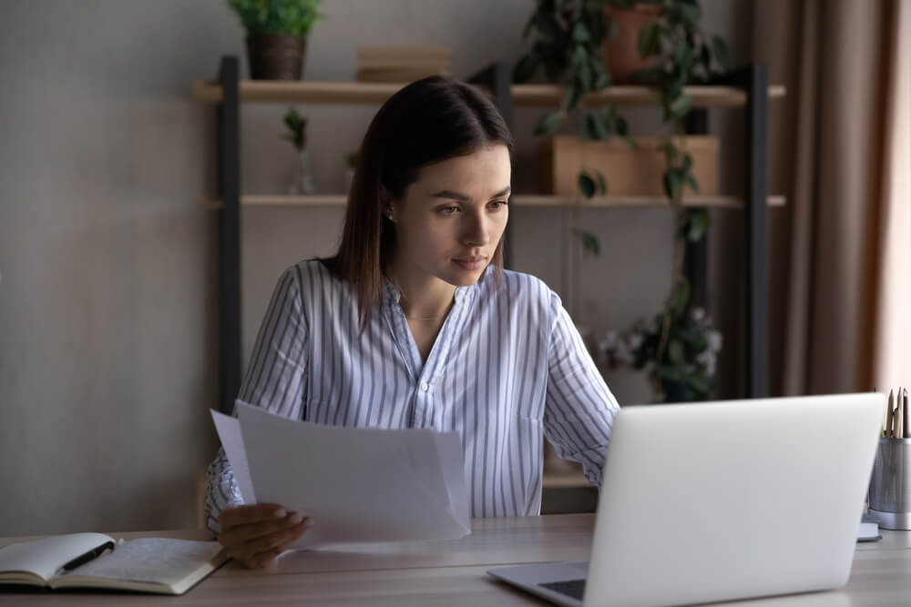 A property title company employee reviewing documents at a desk